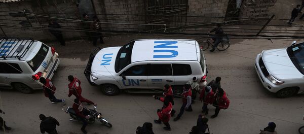 UN vehicles escorting a Red Crescent convoy carrying humanitarian aid arrive in Kafr Batna, in the rebel-held Eastern Ghouta area, on the outskirts of the capital Damascus on February 23, 2016 during an operation in cooperation with the UN to deliver aid to thousands of besieged Syrians - Sputnik Mundo