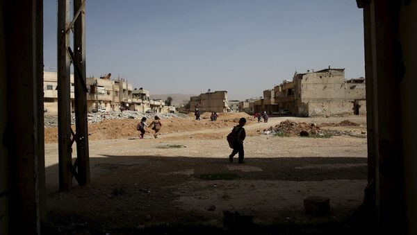 Schoolchildren carry their bags as they walk along a street in the rebel held Douma neighborhood of Damascus, Syria March 27, 2016. - Sputnik Mundo