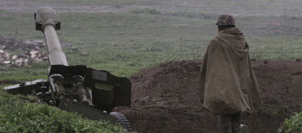 Un soldado de la autodefensa de Nagorno Karabaj cerca de un cañon de artillería - Sputnik Mundo