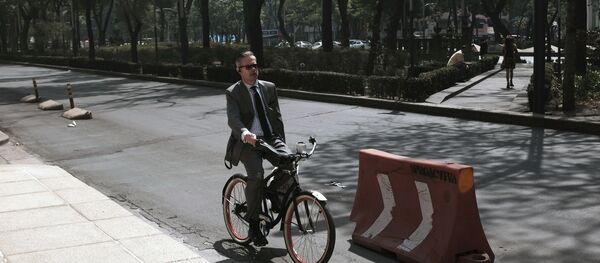 Un hombre en bicicleta durante la jornada bajo contingencia por contaminación en la Ciudad de México - Sputnik Mundo