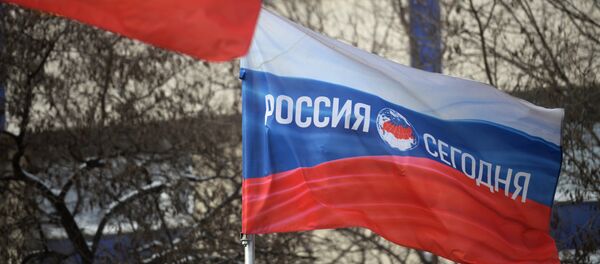Bandera de Rusia con el logo de la agencia de noticias Rossiya Segodnya - Sputnik Mundo