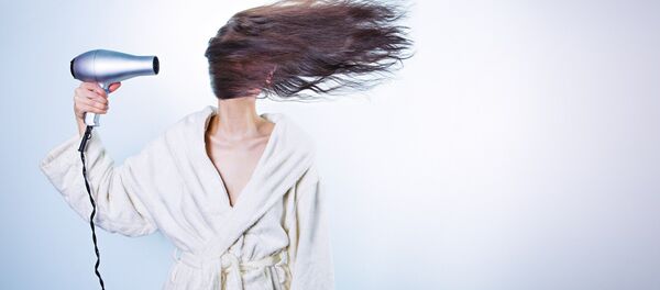 Una mujer con un secador de cabello - Sputnik Mundo