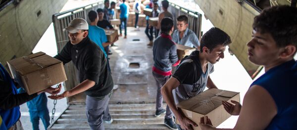 Unloading Russian EMERCOM plane with humanitarian aid which arrived to Latakia Airport in Syria. File photo - Sputnik Mundo