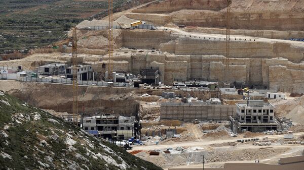 Workers and buldozers work at a construction site on April 14, 2016 in the Israeli settlement of Givat Zeev near the West Bank city of Ramallah. - Sputnik Mundo