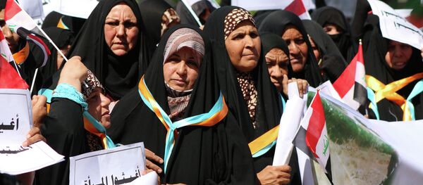 Iraqi women hold placards reading in Arabic: Help women who are abused by DAESH (Islamic State ) during a demonstration to denounce abuse against women by jihadists from the Islamic State - Sputnik Mundo