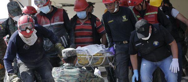 Soldiers and rescue team members carry the body of a victim at a collapsed building after an earthquake struck off the Pacific coast, in Pedernales, Ecuador - Sputnik Mundo