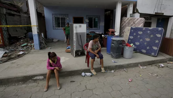 Ecuatorianos en frente de la casa en ruinas - Sputnik Mundo