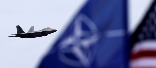 Caza estadounidense F-22 raptor y las banderas de la OTAN y EEUU (archivo) - Sputnik Mundo