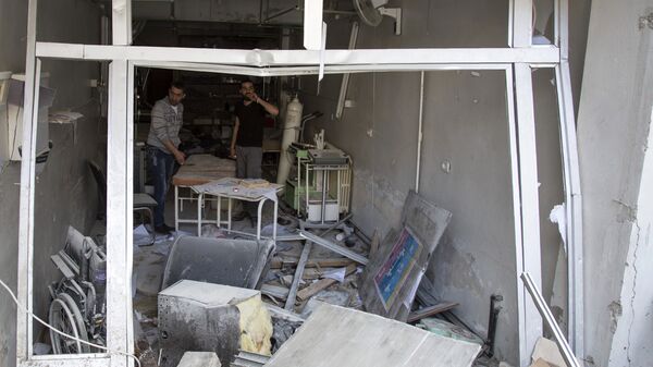 A picture taken on April 28, 2016 shows Syrian men inspecting the damage at the Al-Quds hospital building following reported airstrikes on the rebel-held neighbourhood of Sukkari in the northern city of Aleppo.  - Sputnik Mundo