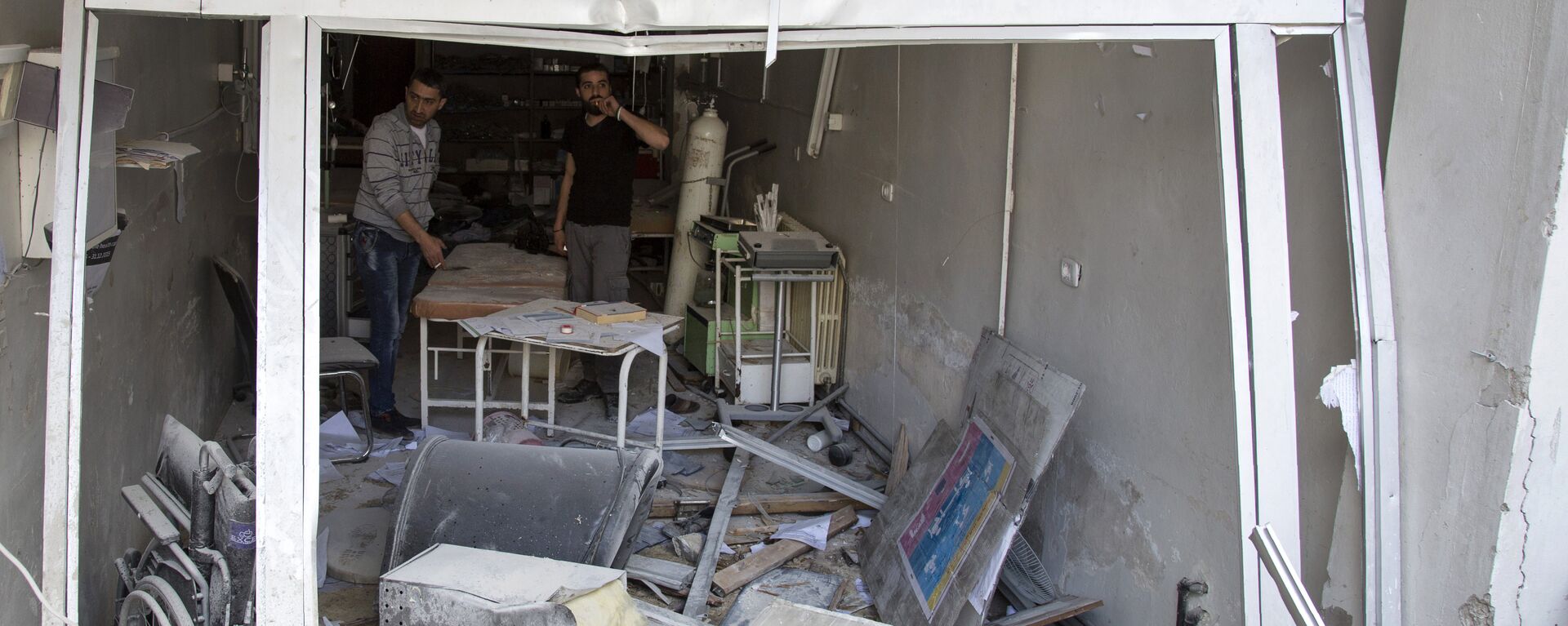A picture taken on April 28, 2016 shows Syrian men inspecting the damage at the Al-Quds hospital building following reported airstrikes on the rebel-held neighbourhood of Sukkari in the northern city of Aleppo.  - Sputnik Mundo, 1920, 10.11.2023