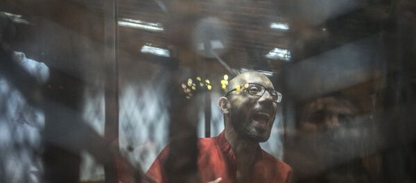 Ahmed Abdel-Aaty, the former head of Egypt's ousted Islamist president's office, wearing a red uniform, stands behind the defendant's bars during his trial at the police academy in Cairo on May 7, 2016 - Sputnik Mundo