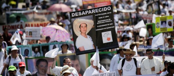 Madres y familiares con las fotos de las personas desaparecidas durante la marcha en el Día de la Madre en la Ciudad de México - Sputnik Mundo