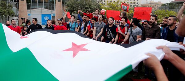 Protesters carry a giant Syrian opposition flag as they take part in a sit-in in solidarity with the people of Aleppo - Sputnik Mundo