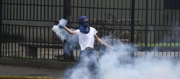 A man protesting against new emergency powers decreed this week by President Nicolas Maduro clashes with policemen in Caracas on May 18, 2016. A man protesting against new emergency powers decreed this week by President Nicolas Maduro clashes with policemen in Caracas on May 18, 2016. - Sputnik Mundo