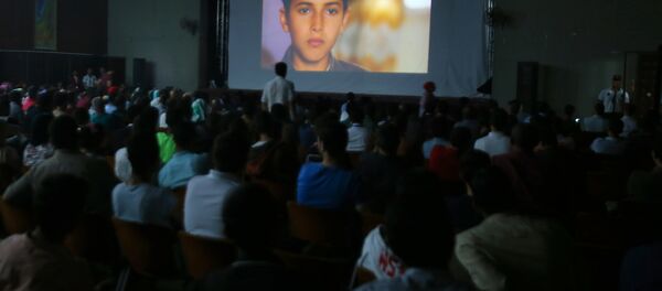 Las familias palestinas durante la proyección de una película en la inauguración del festival de cine La Alfombra Roja en la Franja de Gaza - Sputnik Mundo