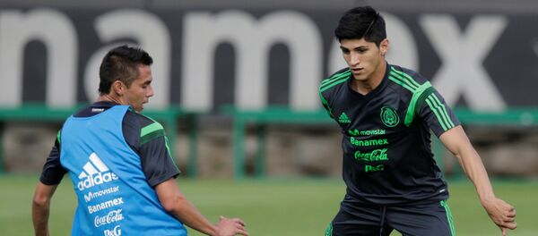 Mexico striker Pulido dribbles the ball past Aguilar during a practice session in Mexico City - Sputnik Mundo