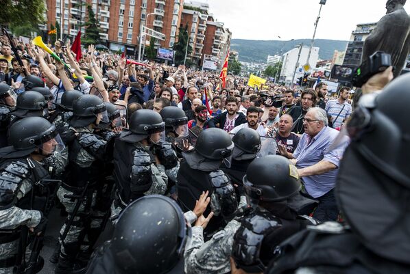 Anti-riot police officers stand guard in front of protestors, during an anti-government protest in Skopje on June 6, 2016 - Sputnik Mundo