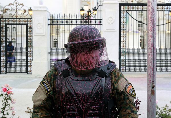 A police officer is splashed after protestors throw balloons filled with colored paint on the Government building during an anti-government protest in Skopje, Macedonia, Monday, June 6, 2016 - Sputnik Mundo