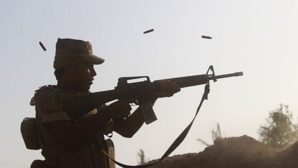 A member of the Iraqi pro-governement forces fires his weapon on a front line in the Albu Huwa area, south of Fallujah near the Euphrates river, on June 1, 2016, - Sputnik Mundo