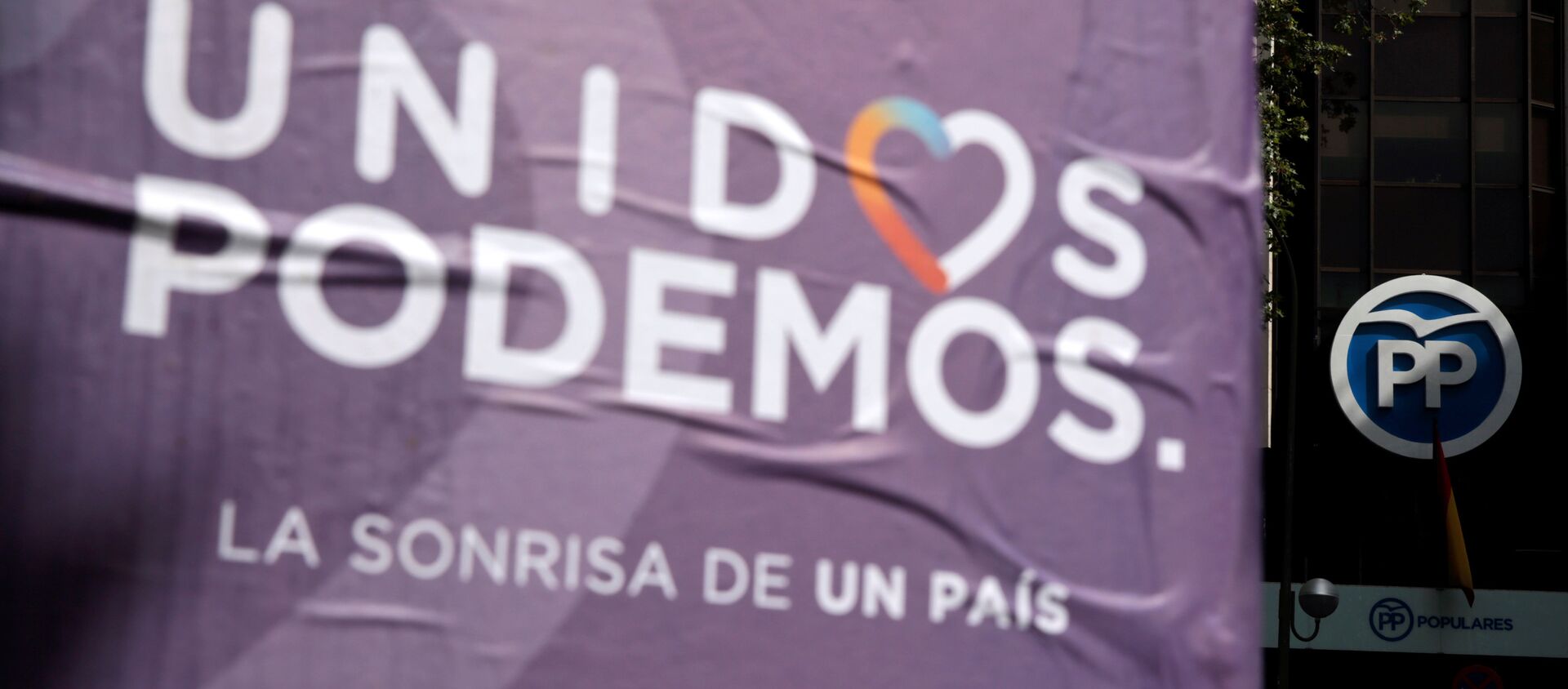 Cartel de la coalición Unidos Podemos al lado de la sede del Partido Popular - Sputnik Mundo, 1920, 11.08.2020