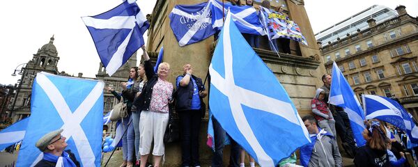 Partidarios de la independencia de Escocia con sus bandreras nacionales - Sputnik Mundo