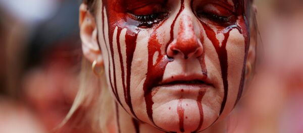 Manifestante cubierta de 'sangre' durante las protestas contra los encierros en las tradicionales celebraciones regionales de San Fermín. Pamplona, España, 5 de julio de 2016. - Sputnik Mundo