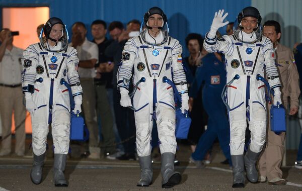 La tripulación de la Expedición 48/49 a la EEI, antes del lanzamiento del cohete portador. De izquierda a derecha, los miembros del equipo de la Expedición 48/49: la astronauta Kathlin Rubins; el cosmonauta Anatoli Ivanishin; y el astronauta japonés Takuya Onishi, antes del despegue desde Baikonur - Sputnik Mundo