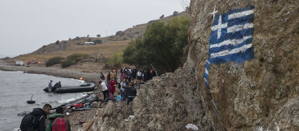 La bandera de Grecia pintada en la roca, los migrantes llegando a las orillas de la isla griega de Lesbos, Sept. 22, 2015 - Sputnik Mundo