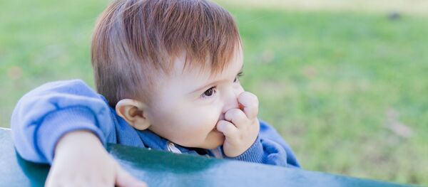 Un niño sosteniendo los dedos cerca de la boca - Sputnik Mundo