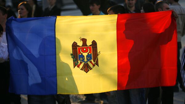 Anti-communist demonstrators hold the Moldovan flag outside the presidential palace Monday April 6, 2009 in Chisinau, Moldova - Sputnik Mundo