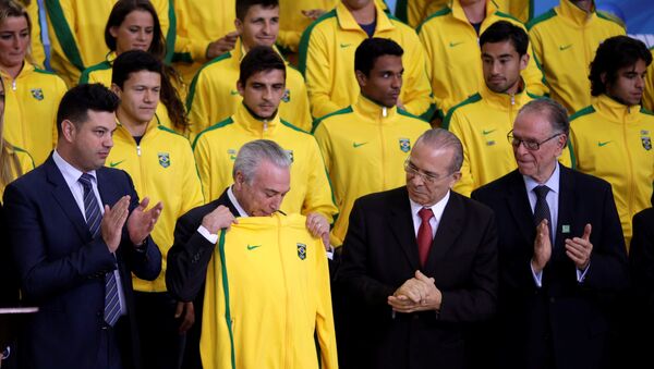 Brazil's interim President Michel Temer receives a jacket for the Brazil uniform, during a presentation ceremony of the Delegation of the Olympic Athletes at the Planalto Palace in Brasilia, Brazil July 13, 2016. - Sputnik Mundo