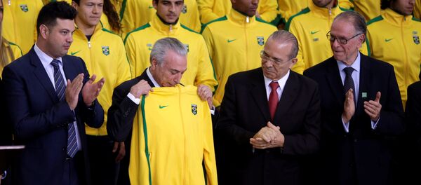 Brazil's interim President Michel Temer receives a jacket for the Brazil uniform, during a presentation ceremony of the Delegation of the Olympic Athletes at the Planalto Palace in Brasilia, Brazil July 13, 2016. - Sputnik Mundo
