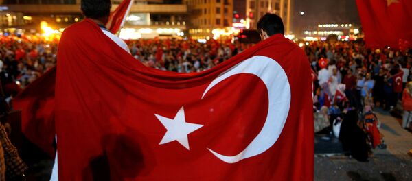 Supporters of Turkish President Tayyip Erdogan are covered with a Turkish national flag during a pro-government demonstration on Taksim square in Istanbul Supporters of Turkish President Tayyip Erdogan are covered with a Turkish national flag during a pro-government demonstration on Taksim square in Istanbul - Sputnik Mundo