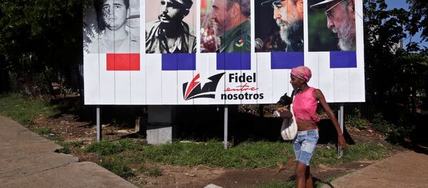 Mujer pasa junto a la pancarta Fidel con nosotros, Cuba - Sputnik Mundo
