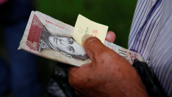 A man holds Venezuelan bolivar notes as he queues trying to buy basic food during a special inspection of Venezuelan soldiers to a municipal market in Caracas, Venezuela July 15, 2016 - Sputnik Mundo