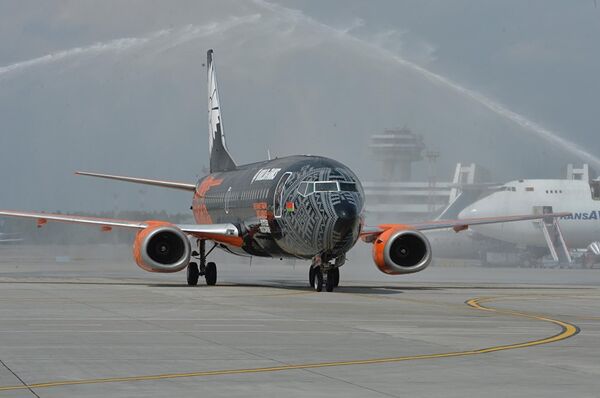 La aeronave pintada con motivos del videojuego de la compañía bielorrusa 'Wargaming' fue recibida con chorros de agua y un arco iris. - Sputnik Mundo