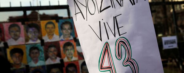 Una mujer sostiene un cartel que pide por la aparición de los 43 estudiantes de Ayotzinapa - Sputnik Mundo