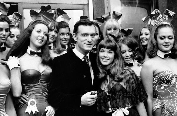 Hugh Hefner y su novia, la actriz de 19 años de edad Barbara Benton, rodeados de conejitas en el Playboy Club de Londres en el año 1969. - Sputnik Mundo