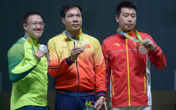 Los ganadores en tiro de pistola de aire de 10 metros masculino durante la ceremonia de premiación. De izquierda a derecha: Felipe Almeida Wua (Brasil) –  medalla de plata, Hoang Xuan Vinh (Vietnam) – Medalla de Oro, Pang Wei ( China) – medalla de bronce. - Sputnik Mundo