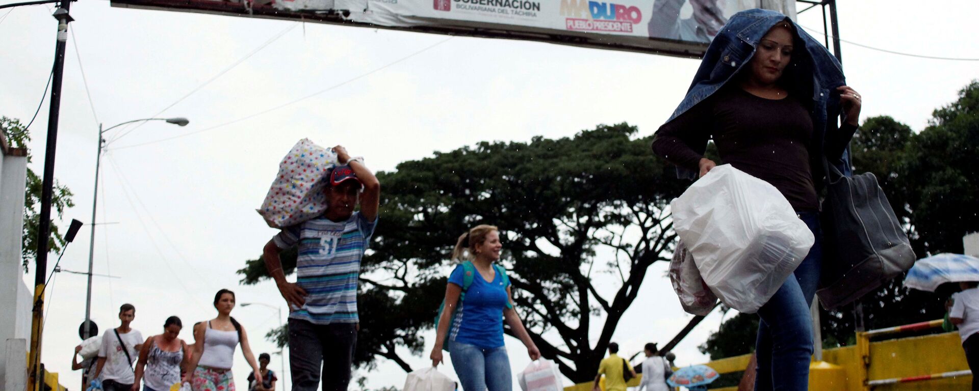 People are seen carrying bags and packages as they cross the Colombian-Venezuelan border People are seen carrying bags and packages as they cross the Colombian-Venezuelan border - Sputnik Mundo, 1920, 22.05.2021