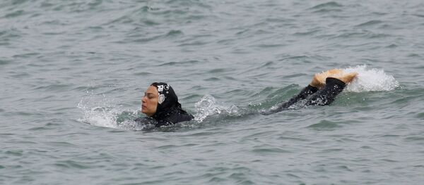 A Muslim woman wears a burkini, a swimsuit that leaves only the face, hands and feet exposed, as she swims in the Mediterranean in Marseille - Sputnik Mundo
