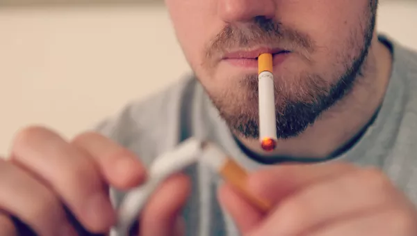 Un hombre fuma un cigarrillo electrónico (imagen referencial) - Sputnik Mundo