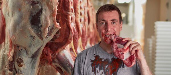 Un hombre comiendo la carne - Sputnik Mundo