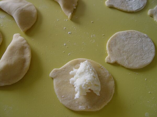 Toma el relleno y con cuidado colócalo en el centro de cada círculo - Sputnik Mundo