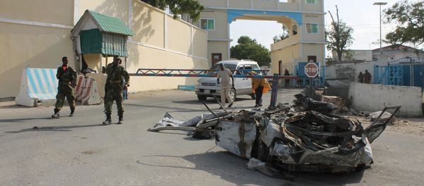 Somali soldiers walk past the wreckage of a car bomb by the main gate outside the presidential palace in Mogadishu (File) - Sputnik Mundo