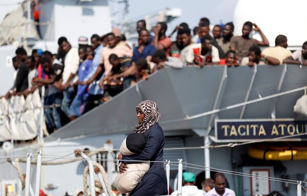 Una mujer sale de una nave marina italiana en el puerto de Pozzallo, Italia. - Sputnik Mundo