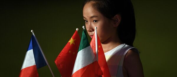 Una niña sostiene las banderas de los países miembros del G20 en la cumbre en Hangzhou - Sputnik Mundo