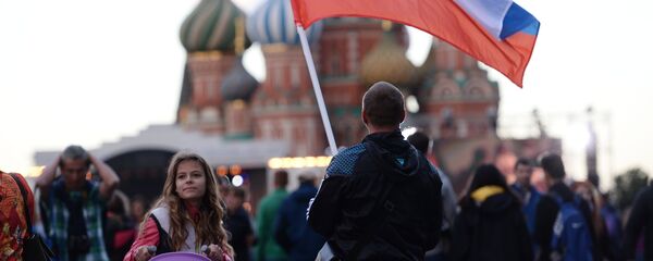 Un hombre con la bandera de Rusia en la Plaza Roja de Moscú - Sputnik Mundo