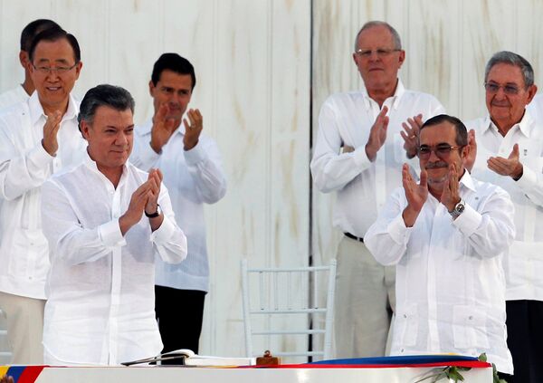 El presidente colombiano, Juan Manuel Santos, y el líder de las FARC, Rodrigo Londoño alias Timochenko  durante la firma del Acuerdo Final sobre la Paz en Cartagena, el 26 de septiembre de 2016 - Sputnik Mundo