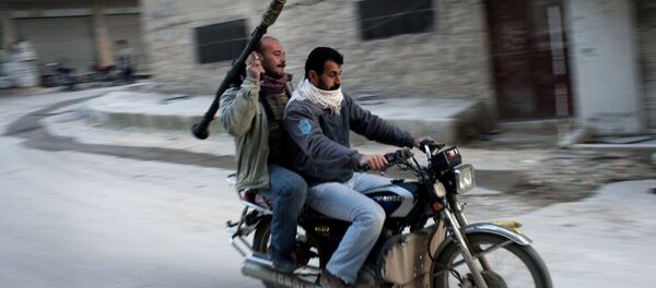 Supporters of the Free Syrian Army ride a motorcycle with a rocket-propelled grenade in Kafar Taharim, Syria. - Sputnik Mundo